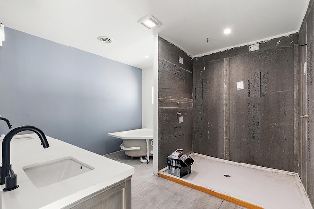 bathroom featuring a shower, visible vents, a sink, and wood finished floors