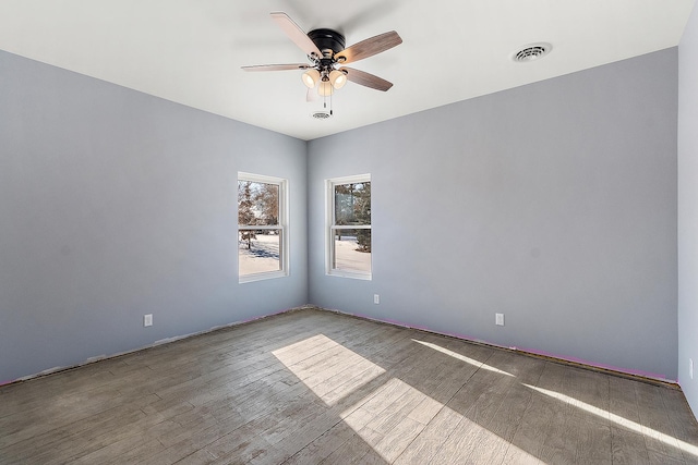 unfurnished room featuring a ceiling fan, visible vents, and wood finished floors