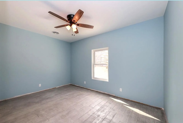 empty room with ceiling fan and light hardwood / wood-style floors