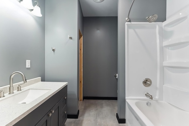 bathroom featuring tub / shower combination, vanity, and wood finished floors