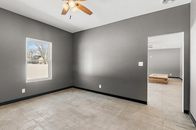 unfurnished room featuring ceiling fan, visible vents, and baseboards