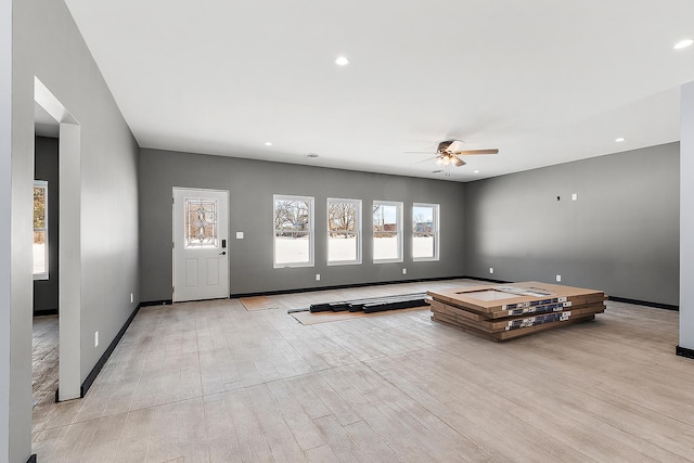 unfurnished living room featuring light wood-style flooring, baseboards, a ceiling fan, and recessed lighting