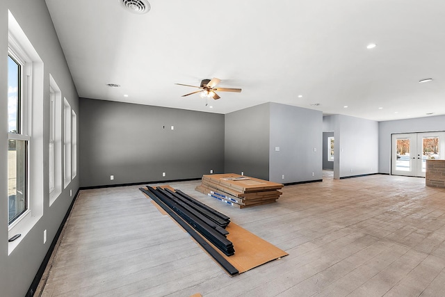 living room featuring light wood-type flooring, ceiling fan, a wealth of natural light, and french doors