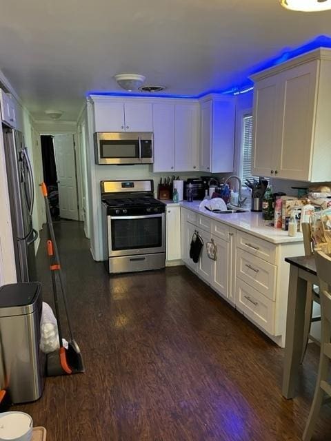 kitchen featuring white cabinetry, appliances with stainless steel finishes, dark hardwood / wood-style floors, and sink