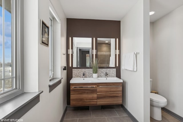 bathroom featuring tasteful backsplash, tile patterned floors, vanity, and toilet