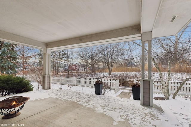 snow covered patio featuring a fire pit