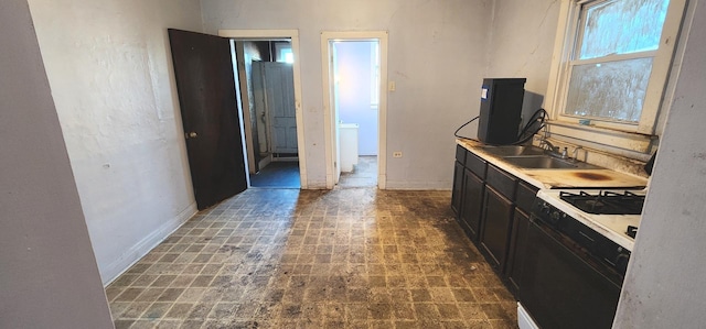 kitchen with gas range, dark brown cabinets, and sink