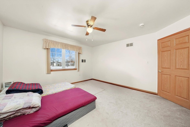 bedroom with light carpet, a ceiling fan, visible vents, and baseboards