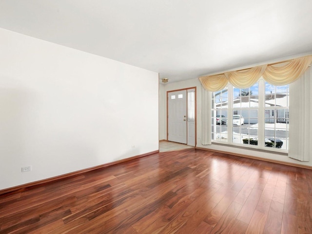 unfurnished room with wood finished floors and baseboards