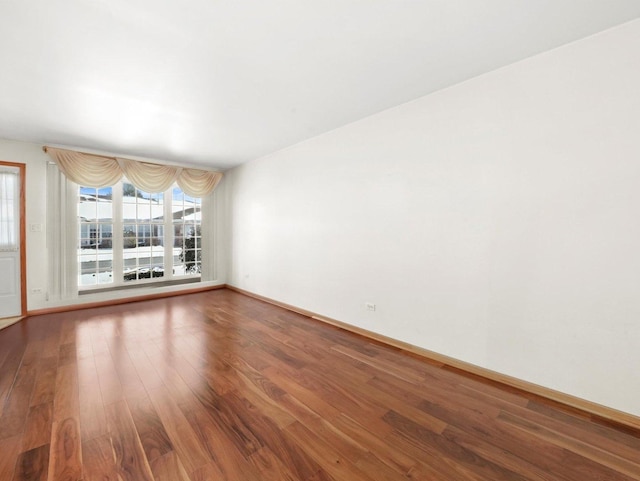 empty room with wood finished floors and baseboards