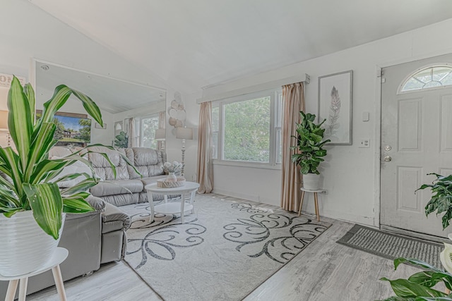 living room featuring lofted ceiling and light hardwood / wood-style flooring