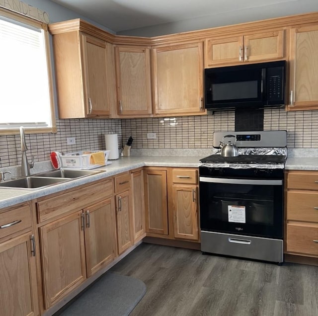 kitchen with dark wood-type flooring, decorative backsplash, stainless steel gas stove, and sink