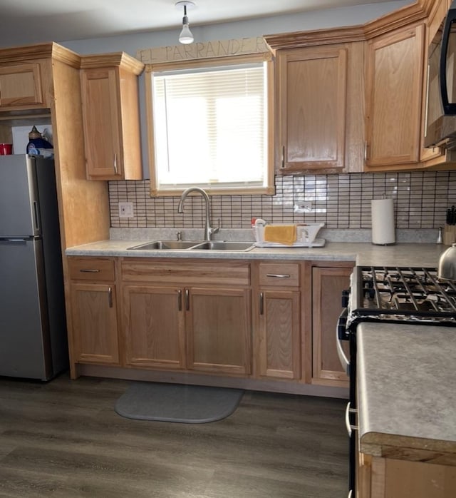 kitchen with range with gas cooktop, dark hardwood / wood-style flooring, decorative backsplash, sink, and stainless steel fridge