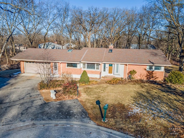 single story home featuring a garage and a front lawn