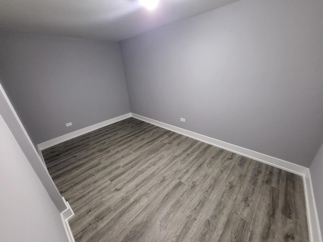 unfurnished room with baseboards and wood finished floors