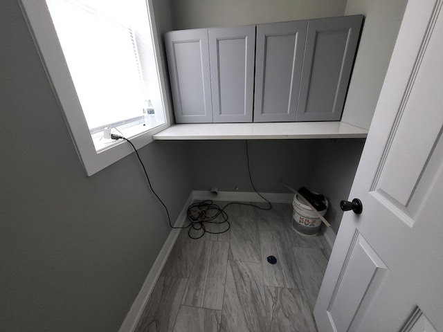 laundry area with baseboards