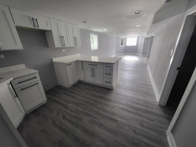 kitchen featuring open floor plan, light countertops, dark wood-style flooring, and white cabinets