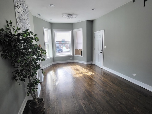 unfurnished room with visible vents, baseboards, and wood finished floors