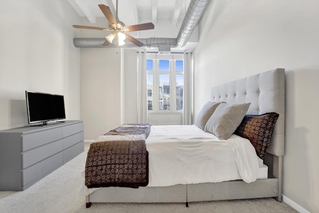 carpeted bedroom featuring ceiling fan and beam ceiling