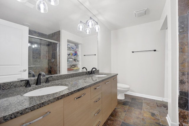 bathroom featuring toilet, a shower with door, and vanity