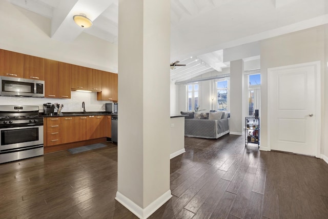 kitchen with appliances with stainless steel finishes, tasteful backsplash, dark hardwood / wood-style flooring, vaulted ceiling with beams, and sink