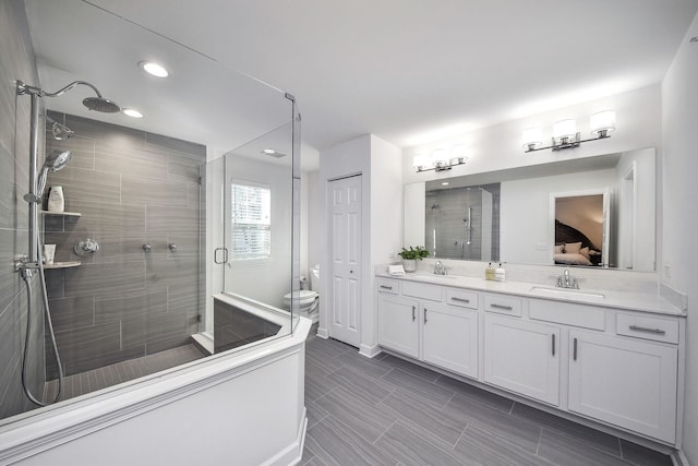 bathroom featuring vanity, an enclosed shower, and toilet