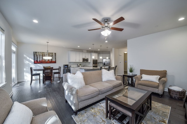 living room with ceiling fan and dark hardwood / wood-style flooring