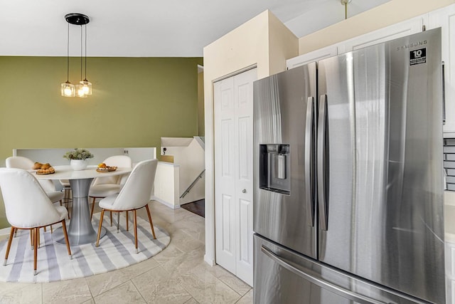 kitchen with stainless steel refrigerator with ice dispenser, white cabinetry, vaulted ceiling, and decorative light fixtures