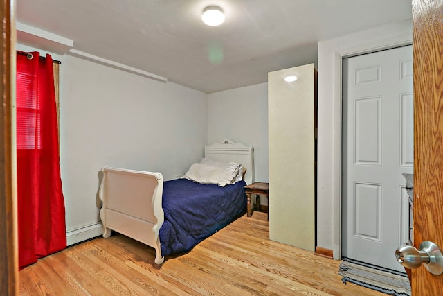 bedroom featuring baseboard heating and light hardwood / wood-style flooring