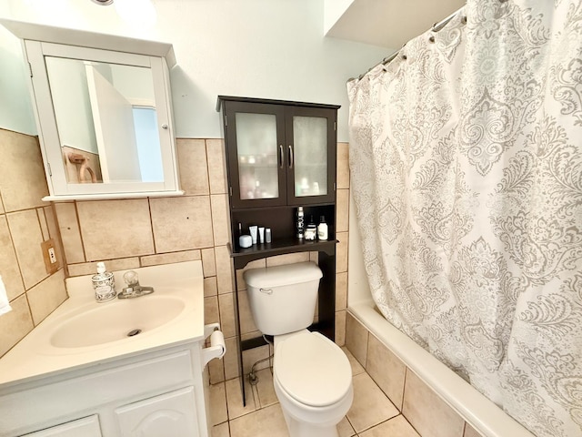 full bathroom featuring toilet, shower / tub combo with curtain, tile patterned flooring, tile walls, and vanity