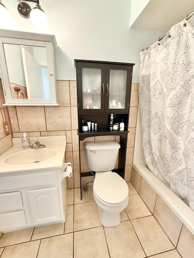 full bathroom featuring toilet, tile patterned flooring, tile walls, and vanity