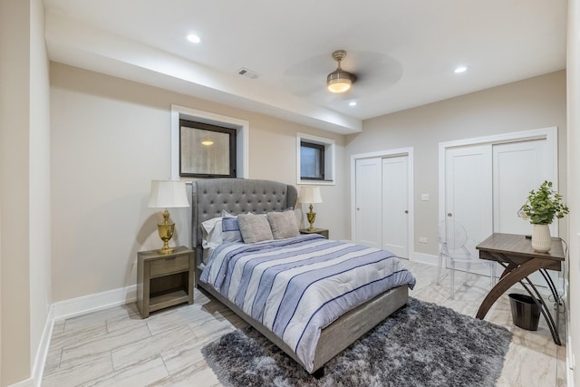 bedroom featuring ceiling fan and two closets