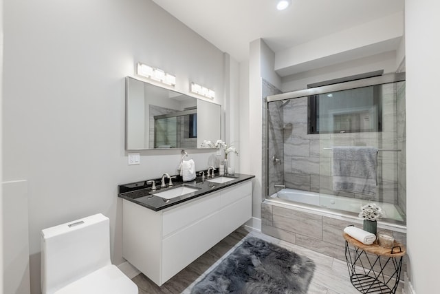 full bathroom featuring toilet, vanity, and combined bath / shower with glass door