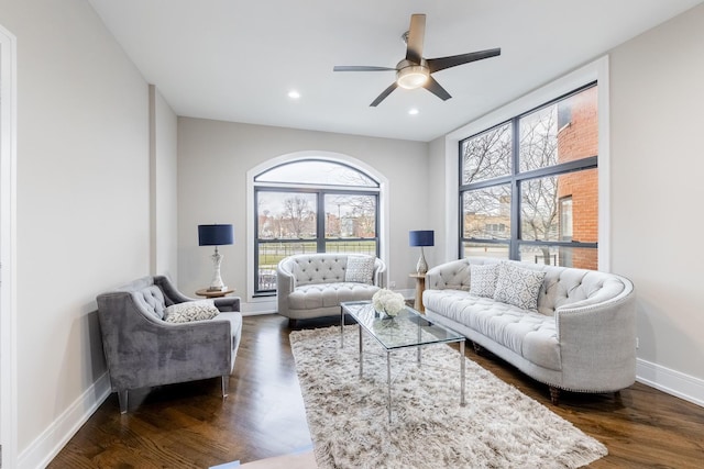 living room featuring ceiling fan and dark wood-type flooring