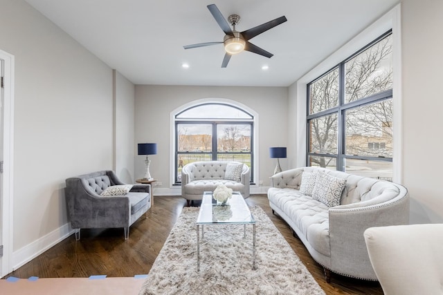 living room with ceiling fan and dark hardwood / wood-style flooring