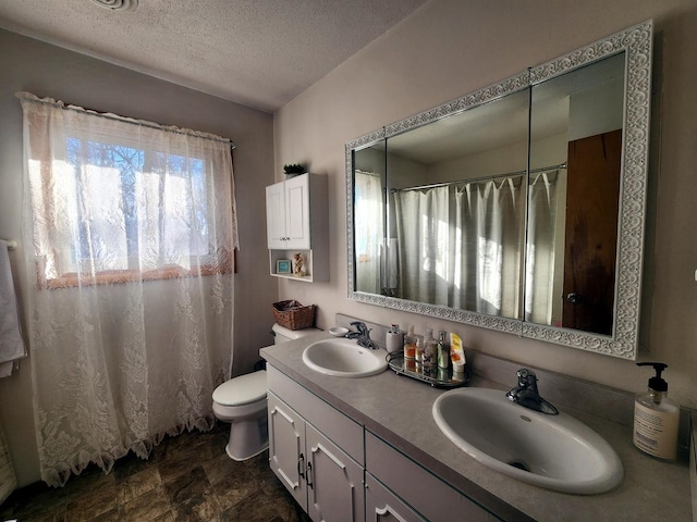 bathroom featuring toilet, vanity, and a textured ceiling