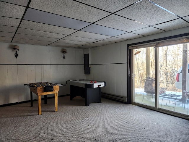 rec room with a baseboard heating unit and light colored carpet