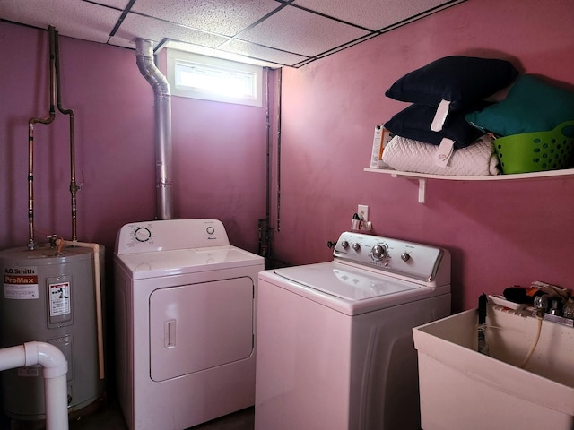 clothes washing area with separate washer and dryer, electric water heater, and sink