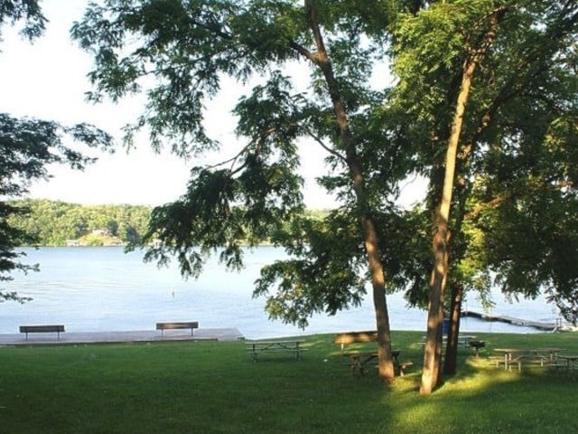 view of property's community with a water view and a yard