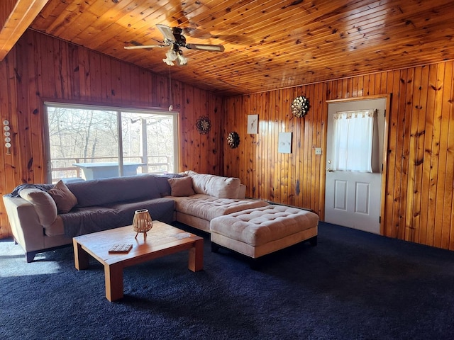 living room with ceiling fan, wood ceiling, dark carpet, and wooden walls