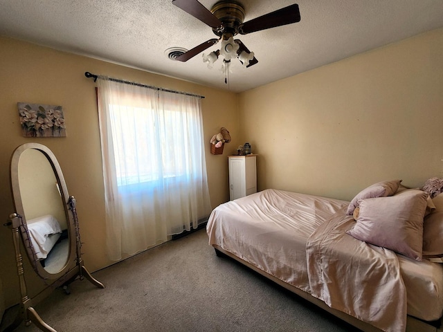 bedroom featuring ceiling fan, light carpet, and a textured ceiling