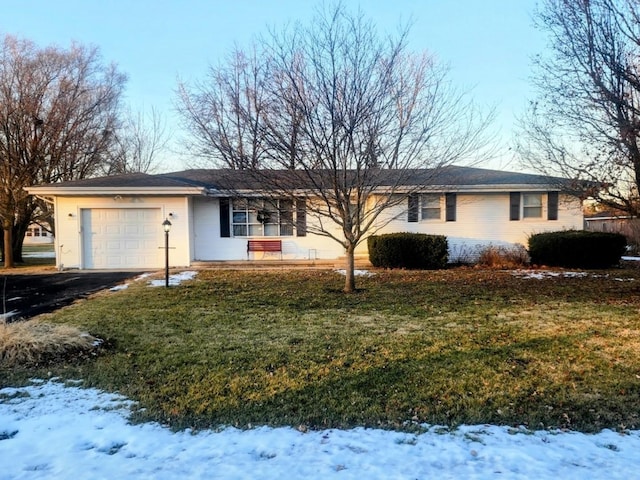 ranch-style house featuring a garage and a yard