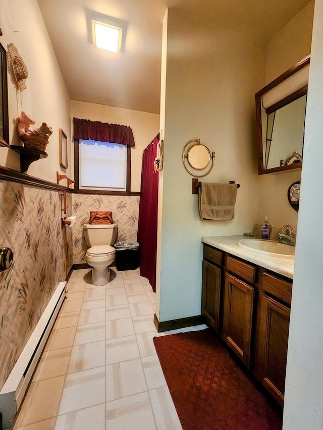 bathroom with toilet, baseboard heating, and vanity