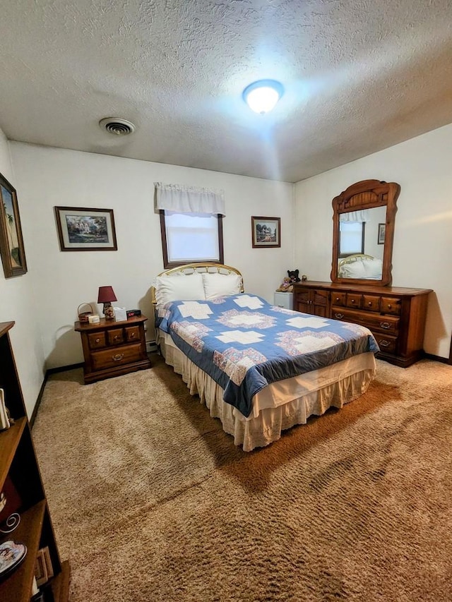 bedroom featuring a textured ceiling and carpet flooring