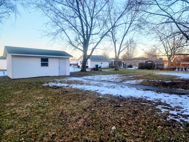 yard layered in snow with an outbuilding