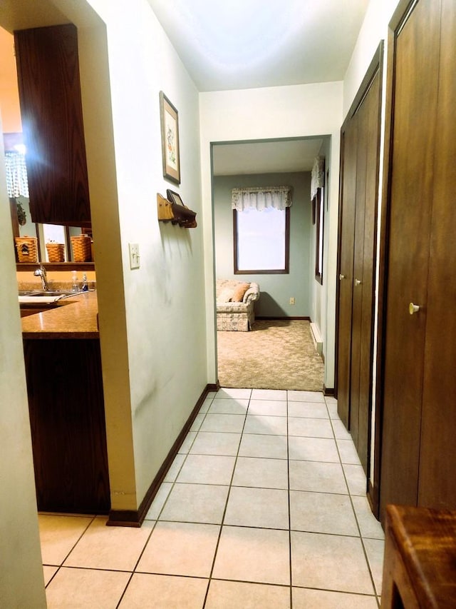 corridor with light colored carpet and sink