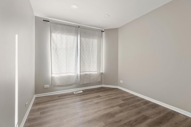 empty room with hardwood / wood-style flooring and a wealth of natural light