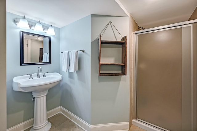 bathroom featuring a stall shower, tile patterned flooring, and baseboards