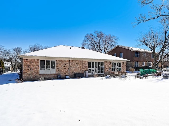 snow covered house with brick siding