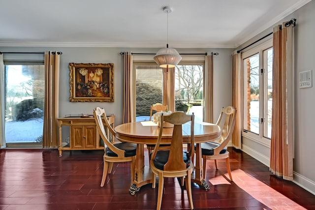 dining room with dark wood-style floors, baseboards, and crown molding